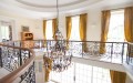 staircase with classic railings, chandelier and curtains