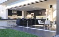 open villa kitchen to the garden with cooking sland and bar stools